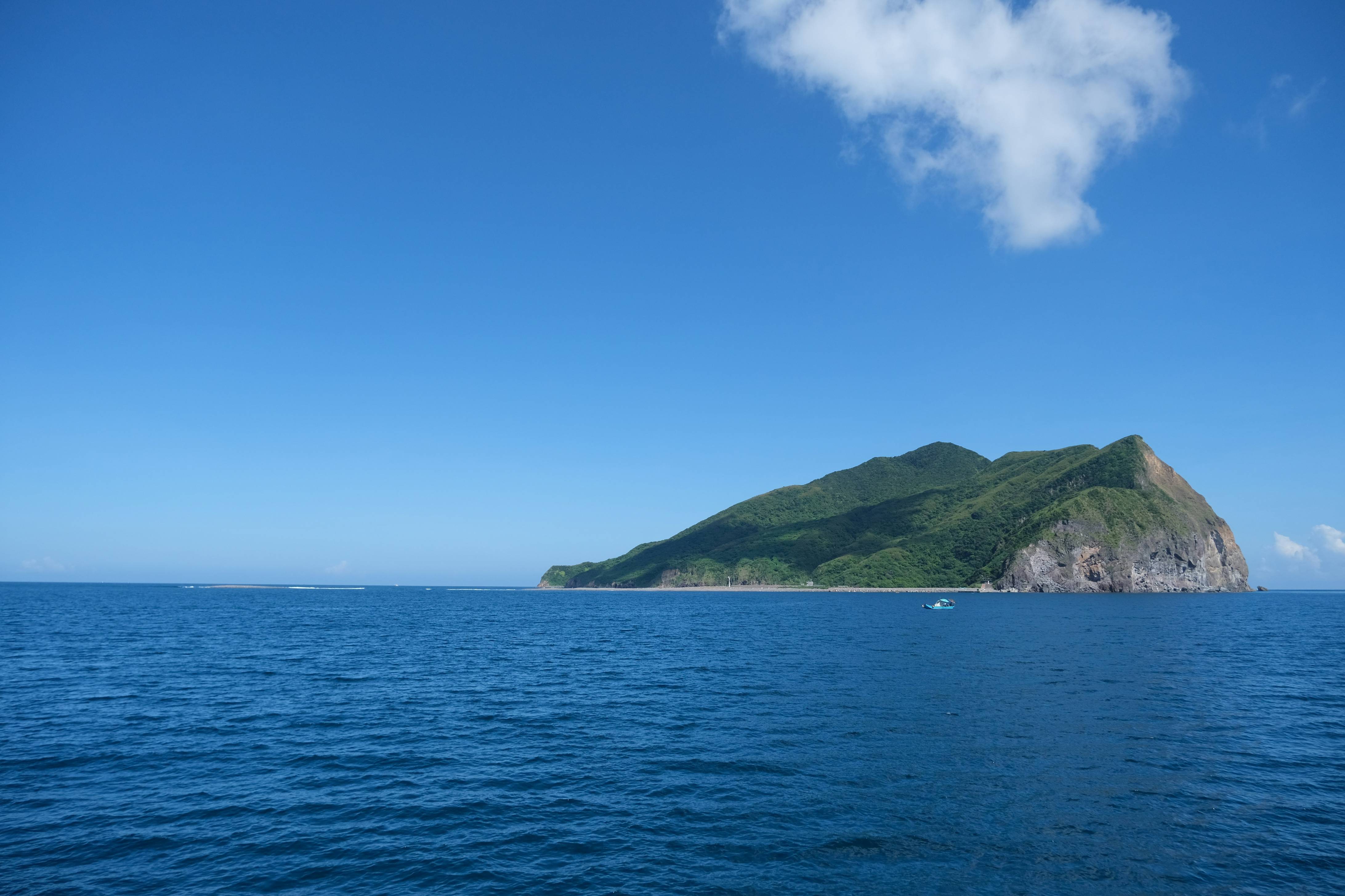 Green island surrounded by blue ocean water